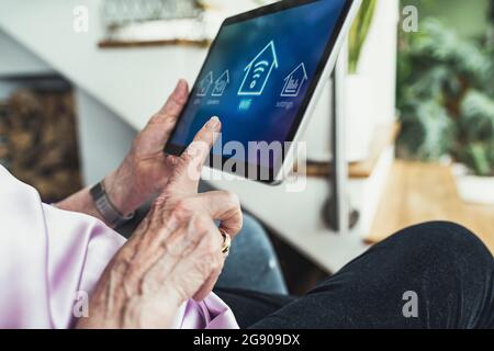 Woman connecting digital tablet with wifi at home Stock Photo
