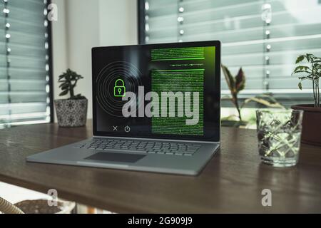 Laptop with padlock icon on table at home Stock Photo