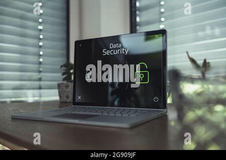 Laptop with data security icons on table at home Stock Photo