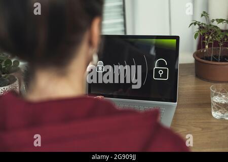 Mature woman accessing security system on laptop at home Stock Photo