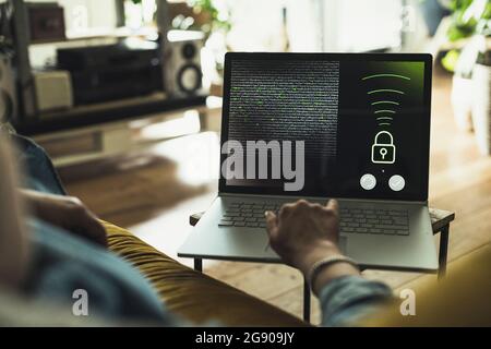 Woman accessing security system on laptop at home Stock Photo