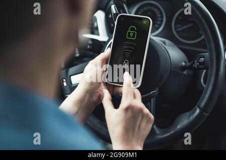 Woman unlocking mobile phone in car Stock Photo