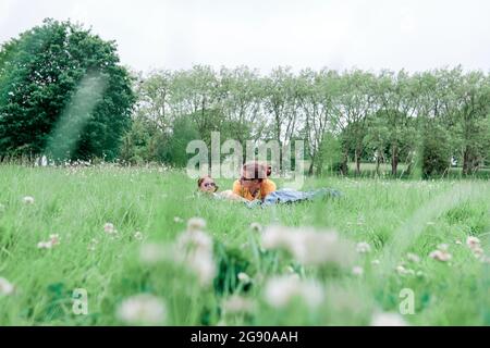Mother and daughter lying on grass in park Stock Photo