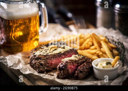 Healthy lean grilled medium-rare steak with french fries, beer Stock Photo