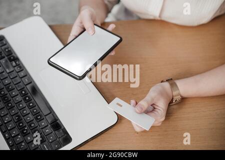 Young businesswoman using credit card to do online shopping at cafe Stock Photo