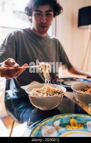 Man having lunch while sitting by dining table at home Stock Photo