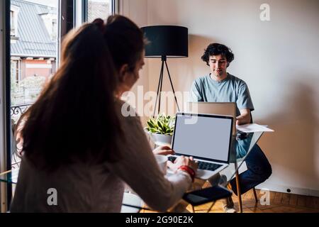 Couple using laptops while working at home Stock Photo