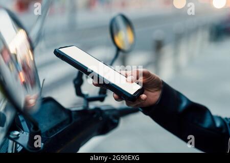 Woman unlocking electric motor scooter through mobile phone Stock Photo