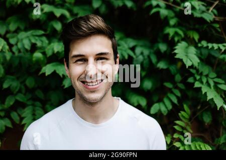 Smiling handsome man in front of tree Stock Photo