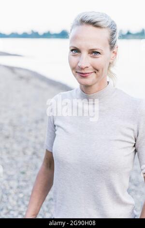 Mature woman smiling at riverbank Stock Photo - Alamy