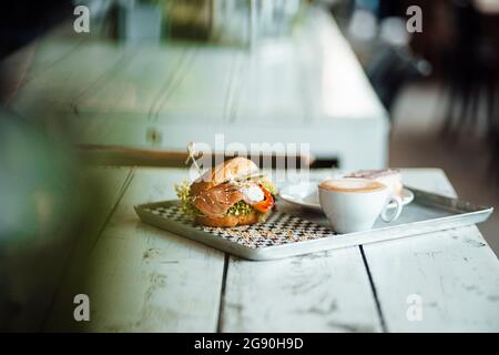 Coffee with bagel and cheesecake in serving tray at cafe Stock Photo