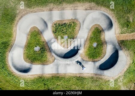 Young man roller skating at skateboard park during sunny day Stock Photo