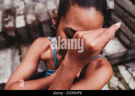 Young woman covering face with hands Stock Photo