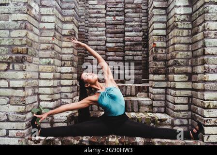 Young female dancer doing stretching on steps Stock Photo