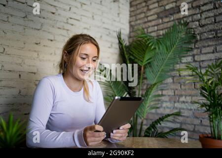 Smiling young businesswoman using digital tablet at home Stock Photo