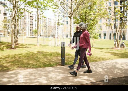 Man and woman walking in public park Stock Photo