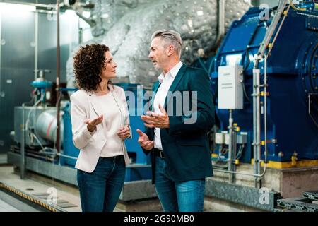 Businessman having discussion with colleague while standing in workshop Stock Photo