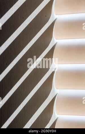 A macro shot of sunlight coming through Venetian blinds creates diagonal stripes of shadow. Stock Photo