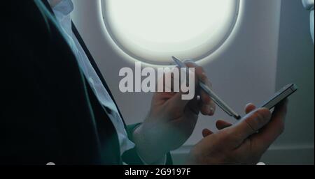 Businessman using smart phone during the flight Stock Photo