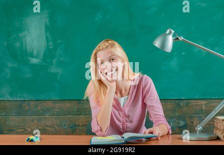 Learn with fun. Funny female teacher sitting at her workplace and teaching English. Education concept Stock Photo