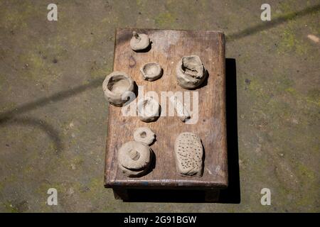 Tiny clay kitchen set. Kids' toys are made of clay. Making small toys with soil and drying them in the sun. Toys made for small children. Stock Photo