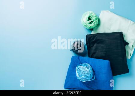 Synthetic polyester fabric microfiber spool of thread on a light blue background Stock Photo