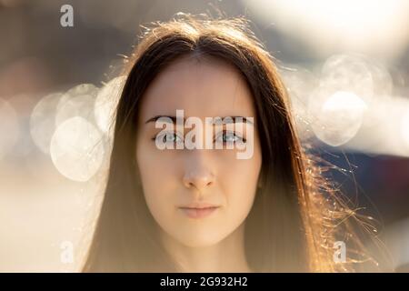 Serious woman with pensive look is posing outside for portrait. Stock Photo