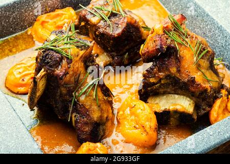 Beef ribs stewed in apricots. Braised meat with fruit sauce Stock Photo