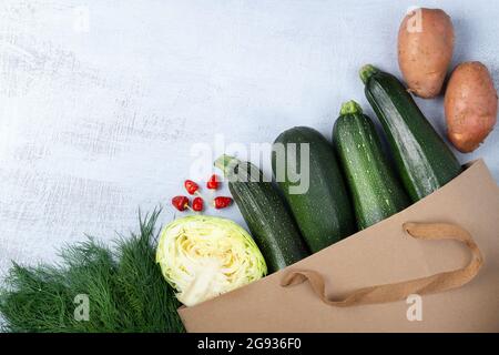 Organic courgette and vegetables in a brown paper bag. Recycle packaging concept. No plastic waste. Space for text Stock Photo