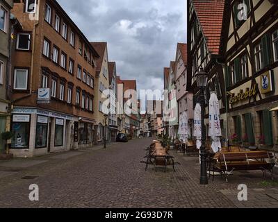 View of shopping street Küferstraße in historic center of Esslingen with shops and restaurants in old buildings on sunday morning on cloudy summer day. Stock Photo