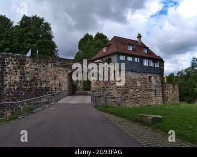 Front view of gate of the historic medieval castle of Esslingen am Neckar, Baden-Württemberg, Germany with thick stone walls, paved road with signs. Stock Photo