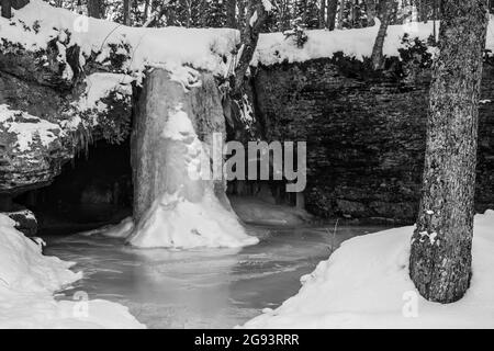Frozen Scott Falls drops about 10 feet over a sandstone cliff into a small pool, in Munising, Michigan. Stock Photo