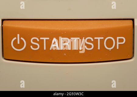 Start and Stop orange button close up symbolize choices to begin or end. Stock Photo