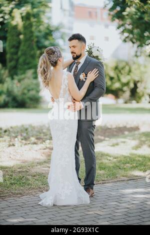 Beautiful wedding couple hugging in the park Stock Photo - Alamy