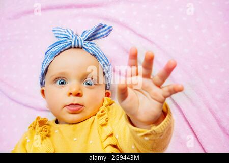 Baby lift up palm reaching with hand stop gesture Stock Photo