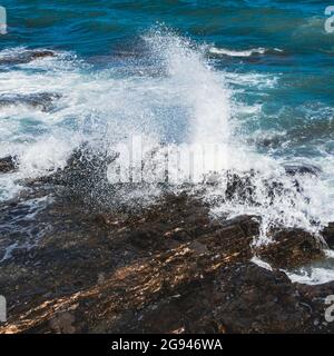 Wave breaking on rock. Stock Photo