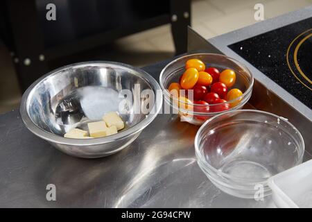 Male chef preparing salad in kitchen. Gourmet chef making delicious dish in restaurant kitchen. Cheese for frying in bowl Stock Photo