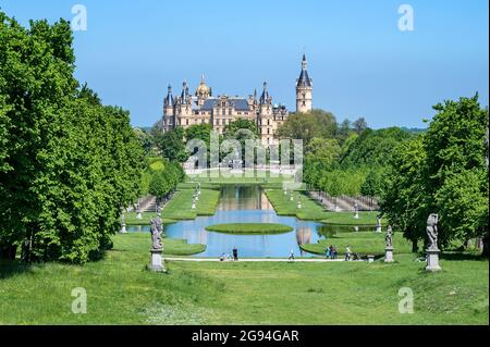 Schwerin castle and park with tourists under a blue sky, famous landmark and travel destination of the state capital city of Mecklenburg-Vorpommern, G Stock Photo