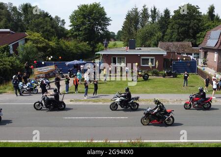 Rhauderfehn, Germany. 24th July, 2021. Motorcyclists ride past the house of Kilian, a cancer patient. Thousands of bikers have followed the calls to give the boy another joy. Several thousand motorcyclists met on Saturday in Rhauderfehn, East Frisia, to make a boy with cancer happy. This was confirmed by the police. The child is a big motorcycle fan. A call in social networks had found great response, bikers from all over Germany were expected in the village in the district of Leer. Credit: Markus Hibbeler/dpa/Alamy Live News Stock Photo