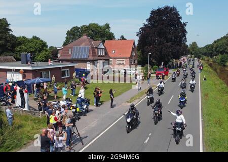 Rhauderfehn, Germany. 24th July, 2021. Motorcyclists ride past the house of Kilian, a cancer patient. Thousands of bikers have followed the calls to give the boy another joy. Several thousand motorcyclists met on Saturday in Rhauderfehn, East Frisia, to make a boy with cancer happy. This was confirmed by the police. The child is a big motorcycle fan. A call in social networks had found great response, bikers from all over Germany were expected in the village in the district of Leer. Credit: Markus Hibbeler/dpa/Alamy Live News Stock Photo