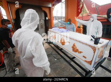 Nonthaburi, Thailand. 24th July, 2021. (EDITORS NOTE: Image depicts death) Buddhist monks and temple workers stand around a coffin of a COVID-19 victim during a funeral ceremony at Wat Bang Muang, in Nonthaburi province, on the outskirts of Bangkok. Thailand has so far confirmed 481,967 Coronavirus cases with 327,789 Recovered and 3,930 Deaths. (Photo by Chaiwat Subprasom/SOPA Images/Sipa USA) Credit: Sipa USA/Alamy Live News Stock Photo