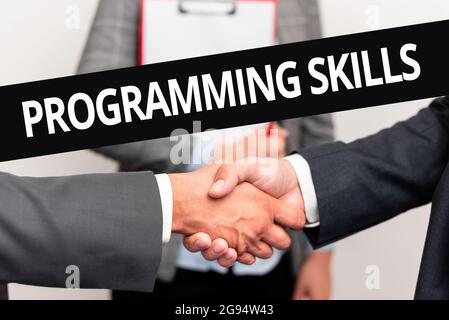 Conceptual display Programming Skills. Word Written on skills vital to write a program so computer can process Two Professional Well-Dressed Corporate Stock Photo