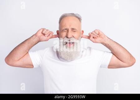 Portrait of attractive funky middle-aged man closing ears yelling avoiding conflict isolated over white pastel color background Stock Photo