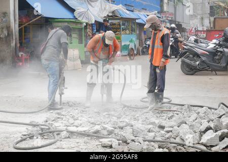 Construction workers are using jack hammer tools to destroy the street concrete. Stock Photo