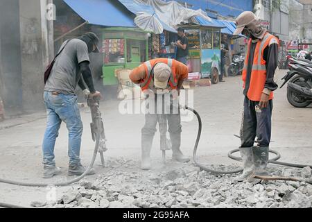 Construction workers are using jack hammer tools to destroy the street concrete. Stock Photo