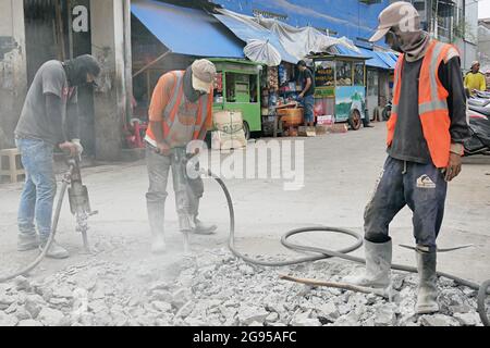 Construction workers are using jack hammer tools to destroy the street concrete. Stock Photo