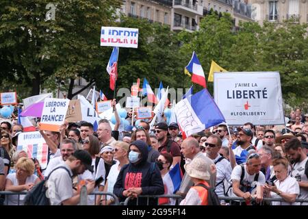 Protesters hold flags and placards during a protest against the compulsory vaccination for certain workers and the mandatory use of the health pass called by the French government, on the 'Droits de l'homme' (human rights) esplanade at the Trocadero Square in Paris, France, on July 24, 2021. Since July 21, people wanting to go to in most public spaces in France have to show a proof of Covid-19 vaccination or a negative test, as the country braces for a feared spike in cases from the highly transmissible Covid-19 Delta variant. Stock Photo