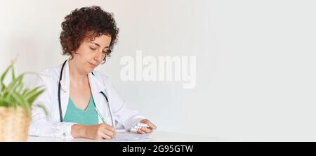 A female doctor focused working in her office Stock Photo