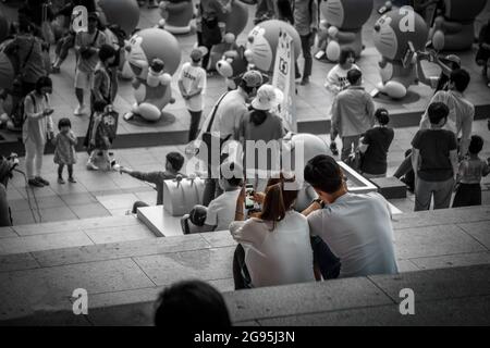 YONGSAN, KOREA, SOUTH - Jun 24, 2015: A grayscale shot of Korean couple in Yongsan Station with the crowd in South Korea Stock Photo