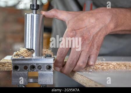 The carpenter works as a professional tool for drilling wood. Stock Photo